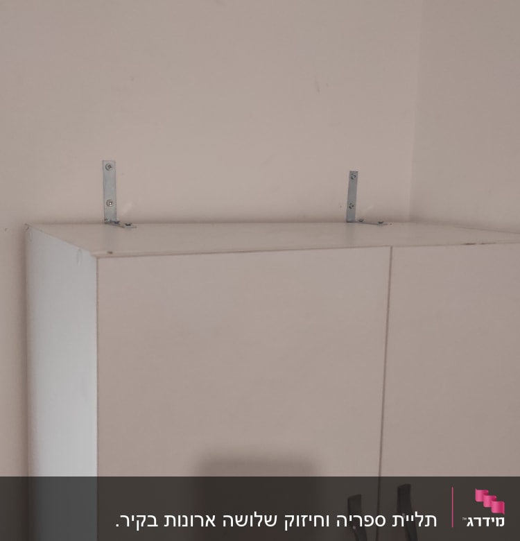 ארון עם ידיות מתכת וסוגרי מתכת על הקיר